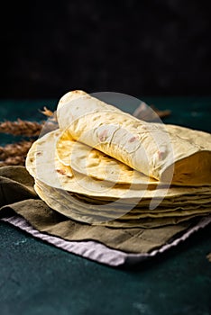 Lavash flat bread on green background