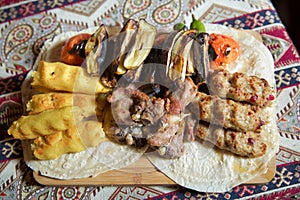 Lavash and kebab on the board. azeri kebab is served with lula kabab . Meat, potatoes, tomatoes, eggplant kebabs