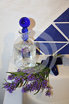 Lavender blossoms, a bottle of glass with oil, water photo