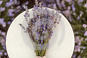 Lavender bouquet on a wooden bench in lavender field