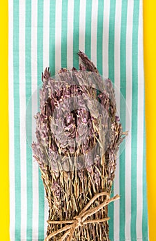 Lavender bundle on folded towel, and vivid yellow background.