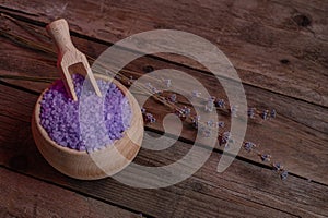 Lavender cooking salt in wooden bowl with spoon on devan background, rustic style