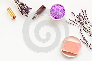 Lavender cosmetics. Violet spa salt, soap, essence oil on white background top-down copy space