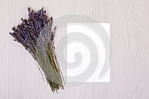 Lavender desk with flowers on background top view mock up.White paper postcard