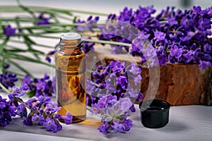 Lavender essential oil bottle with fresh flowers