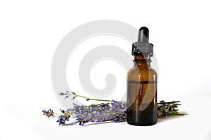 Lavender essential oil in a brown glass bottle with a lavender flowers isolated on white background