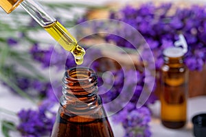 Lavender essential oil drop from pipette over the bottle