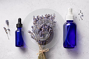 Lavender essential oil, mist in blue bottles and dried flowers