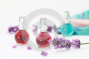 Lavender essential oil in small bottles with fresh lavender petals and flowers