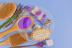 lavender extract cosmetic. Lavender bath salt with lavender extract and body care brushes on a blue background. View