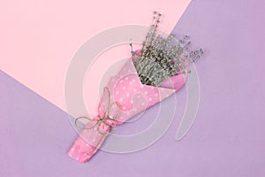 Lavender flower bouquet on pink and lilac background. Minimal floral summer concept in pastel colors