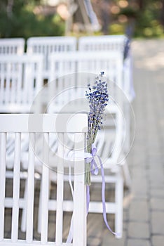 Lavender flowers. Backrest of a chair decorated with a bouquet of lavender. Wedding chair decorated with a lavender flower. Weddin