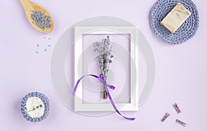 Lavender flowers in a frame on a purple background. cosmetic set with lavender herbs, handmade soap bars and sea salt.