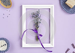 Lavender flowers in a frame on a purple background. cosmetic set with lavender herbs, handmade soap bars and sea salt.