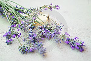 Lavender flowers and natural soap for bodycare on concrete background.