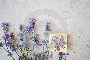 Lavender flowers and natural soap for bodycare on concrete background.