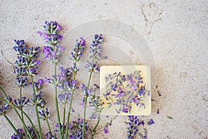 Lavender flowers and natural soap for bodycare on concrete background.