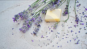 Lavender flowers and natural soap for bodycare on concrete background.