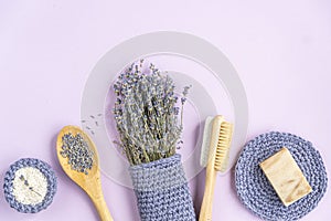 Lavender flowers on a purple background. cosmetic set with lavender herbs, handmade soap bars and sea salt.