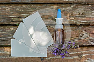 Lavender, handkerchiefs and nasal spray for immediate help with cold as a wooden background photographed from above