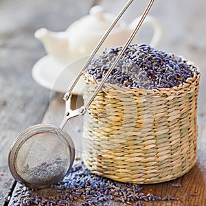 Lavender herbal tea in basket, tea infuser and teapot photo