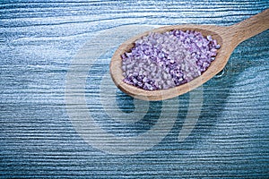 Lavender mineral sea salt in wooden spoon on wood board spa trea