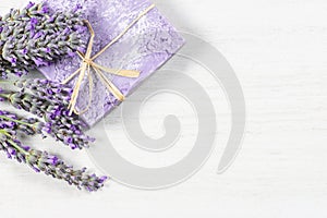 Lavender natural soap with fresh lavender flowers on white rustic table, aromatherapy spa massage concept