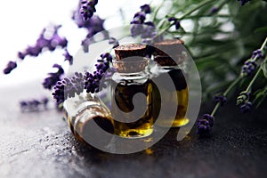 Lavender oil in a glass bottle on a background of fresh flowers