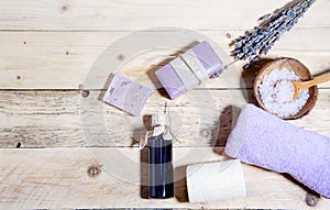 Lavender oil, soap with lavender, flavored salt and a bouquet of dry lavender lie on a wooden surface. Body and face care. CPA