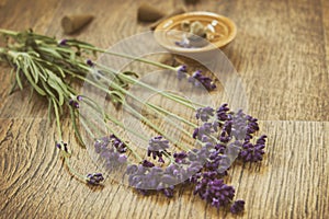 Lavender purple flowers and incense aroma cones on a wooden table.