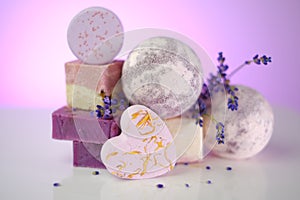 Lavender soap.Bars of purple soap and lavender flowers on a light purple background. set of soap and bade bombs with