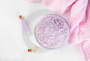 Lavender spa setting: salt, essential oil and dried flowers natural spa products and decor for bath on light background