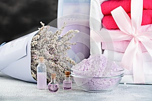 Lavender spa setting: salt, essential oil and dried flowers natural spa products and decor for bath on light background