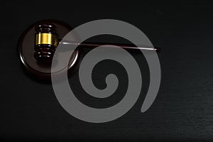 Law or auction gavel on a wooden office desk.