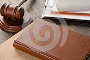 Law book, gavel and documents on wooden table