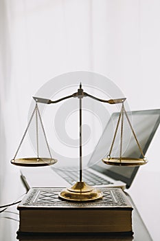 law books and scales of justice on desk in library of law firm. jurisprudence legal education concept