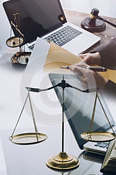 law books and scales of justice on desk in library of law firm. jurisprudence legal education concept