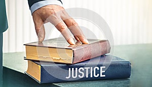 Law concept - Book with the text Justice of laws on the table in the hall in the law enforcement office, on a white background