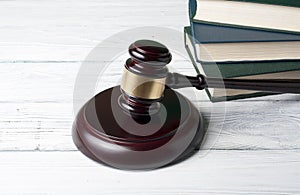 Law concept - Book with wooden judges gavel on table in a courtroom or enforcement office.