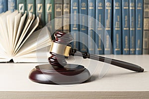 Law concept - Book with wooden judges gavel on table in a courtroom or enforcement office.