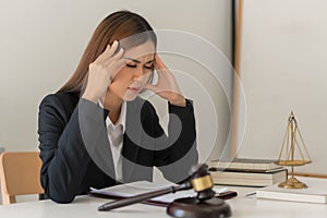 Law concept, Female lawyer feel stress and headache while reading contract of business in law firm