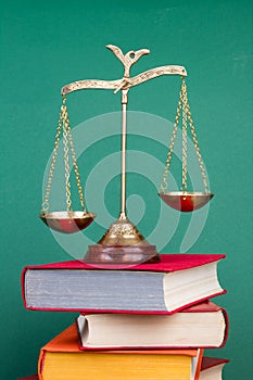 Law concept - Open law book, scales on table in a courtroom or law enforcement office photo