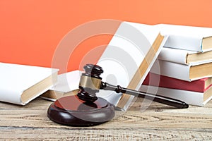 Law concept - Open law book with a wooden judges gavel on table in a courtroom or law enforcement office isolated on white