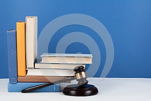 Law concept open book with wooden judges gavel on table in a courtroom or law enforcement office, blue background. Copy