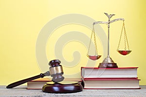 Law concept - Open law book, Judge\'s gavel, scales on table in a courtroom or law enforcement office