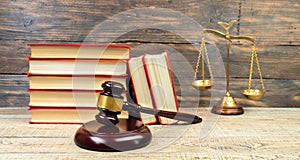 Law concept - Open law book, Judge\'s gavel, scales on table in a courtroom or law enforcement office photo