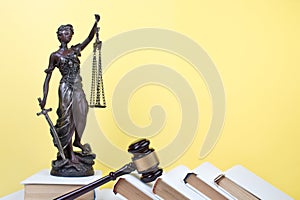 Law concept - Open law book, Judge's gavel, scales, Themis statue on table in a courtroom or law enforcement office.