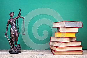 Law concept - Open law book scales, Themis statue on table in a courtroom or law enforcement office