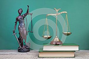 Law concept - Open law book, scales, Themis statue on table in a courtroom or law enforcement office