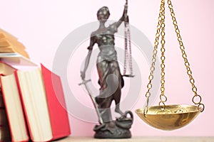 Law concept - Open law book, scales, Themis statue on table in a courtroom or law enforcement office